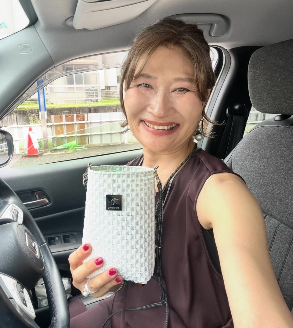 白いスマホバッグを持つ大人女性