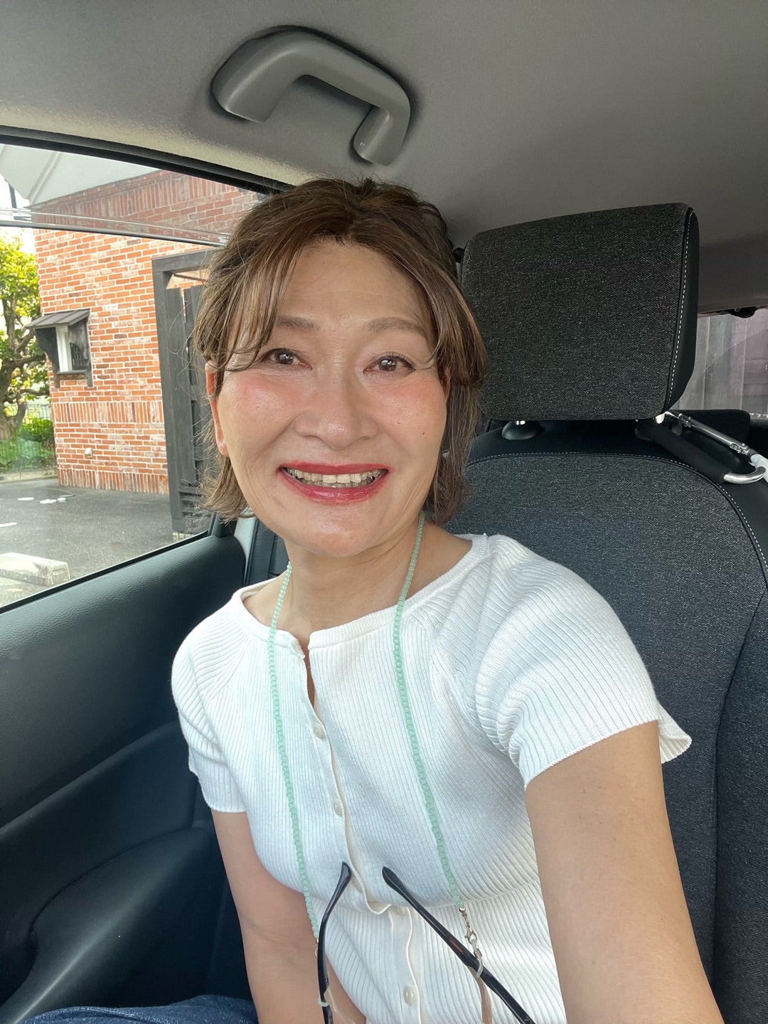 車内で笑顔を見せる三村由香