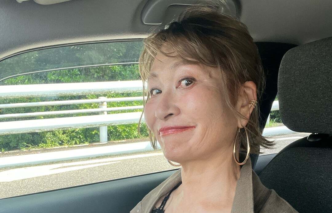 カーキと黒レースの装いでエレガントに微笑む三村由香