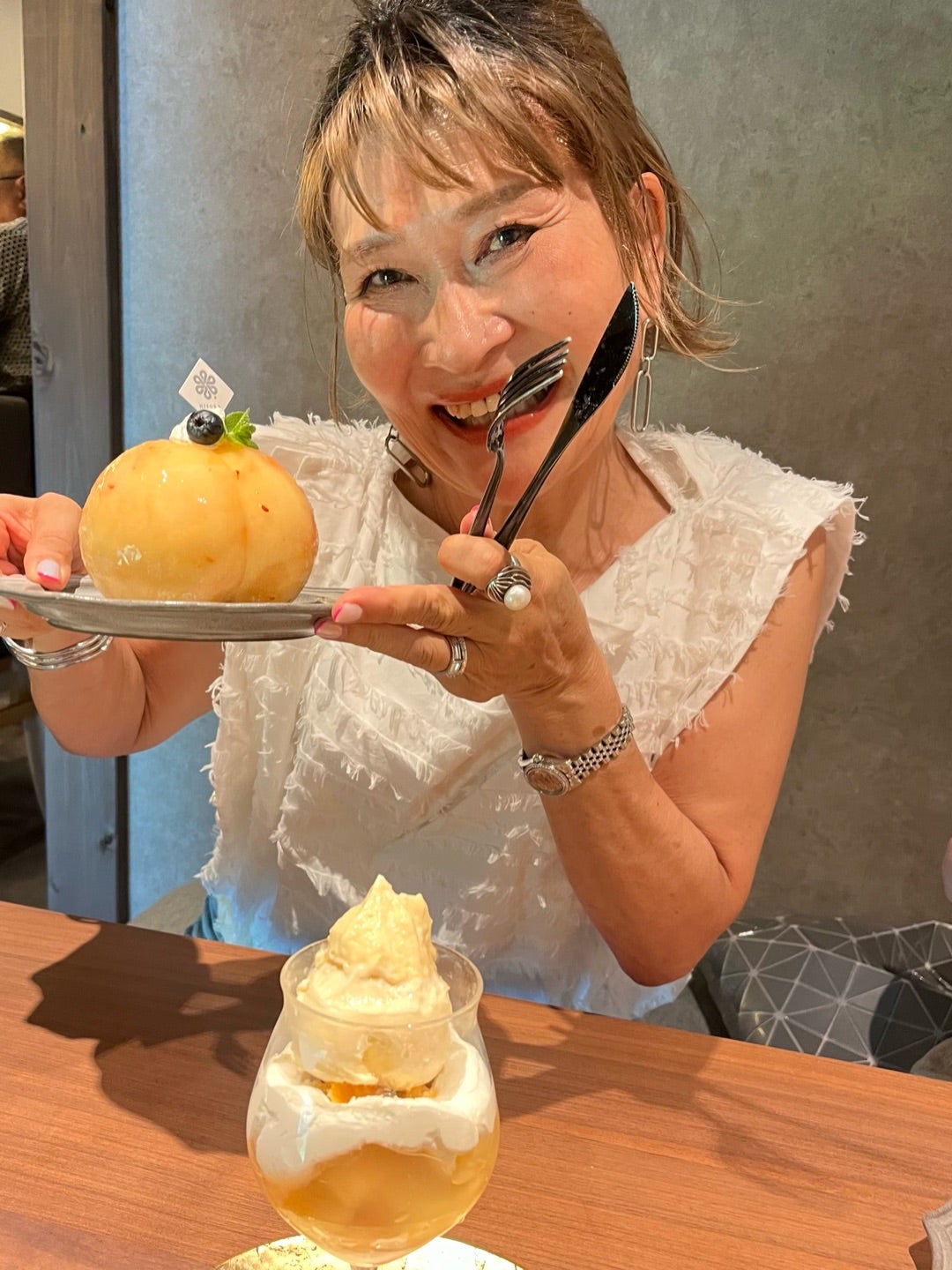 桃を手に明るく笑う66歳の三村由香