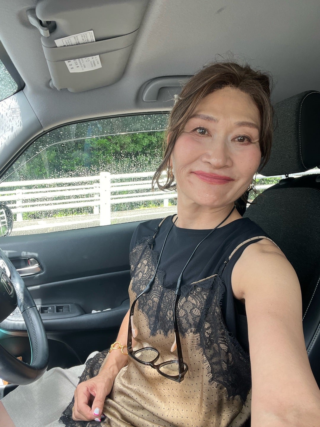 黒レーストップスを着て車内で笑顔を見せる三村由香