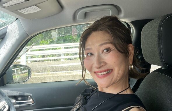黒レースのトップスを着て車内で微笑む三村由香