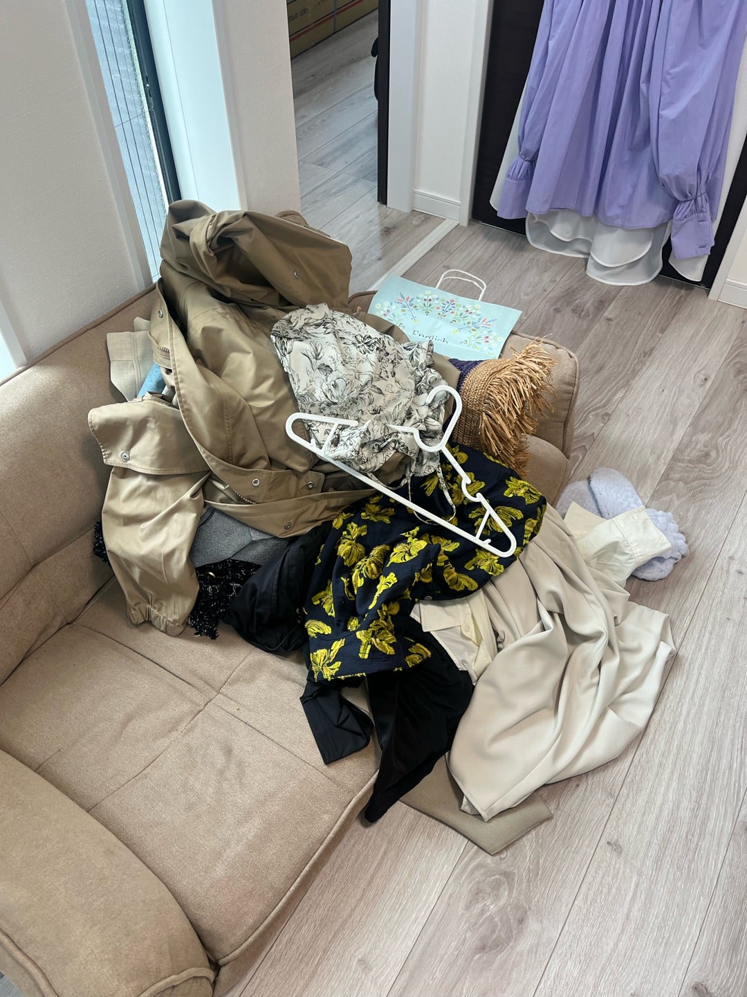 ソファに置かれた服とハンガーを確認している様子