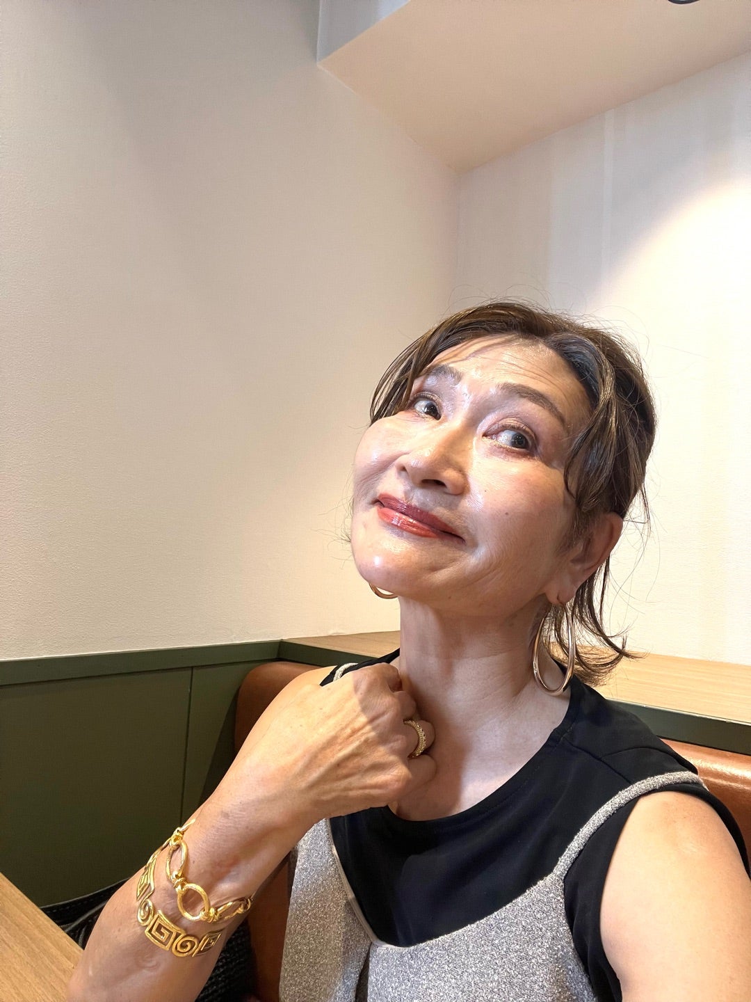 黒とグレーの装いで穏やかに微笑む三村由香