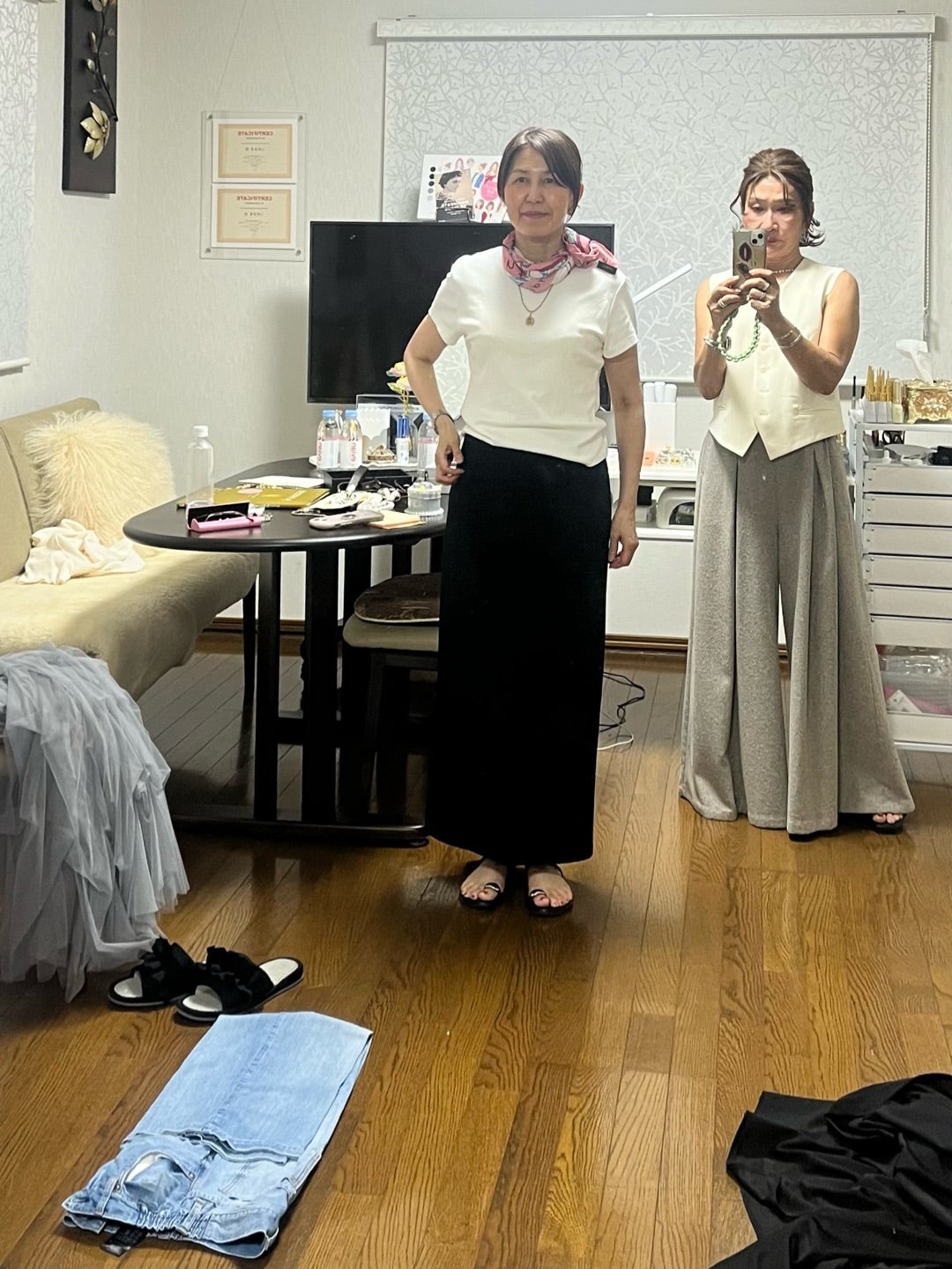 白いトップスと黒いスカートにジュエリーを合わせた装い