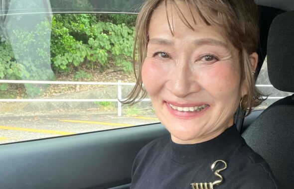 黒いノースリーブにゴールドのブローチを合わせた晩夏の装い