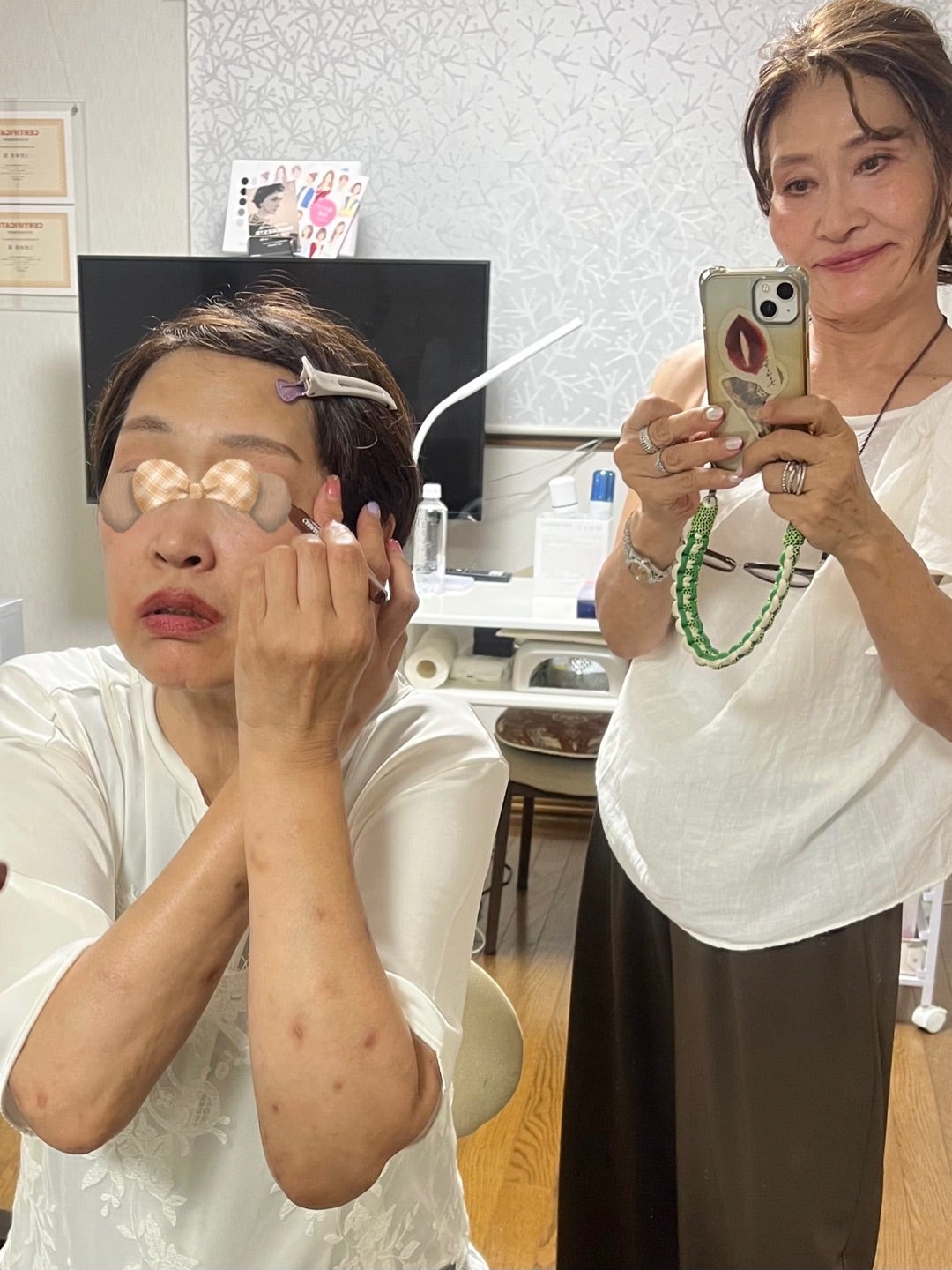 鏡を見ながらアイメイクを練習する女性