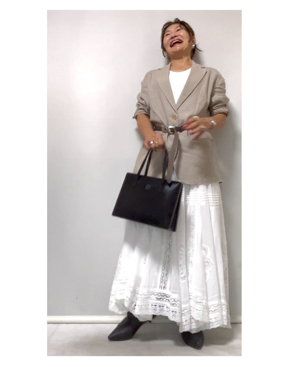 黒いバッグとブーツで白いロングスカートを秋らしく整えたコーデ