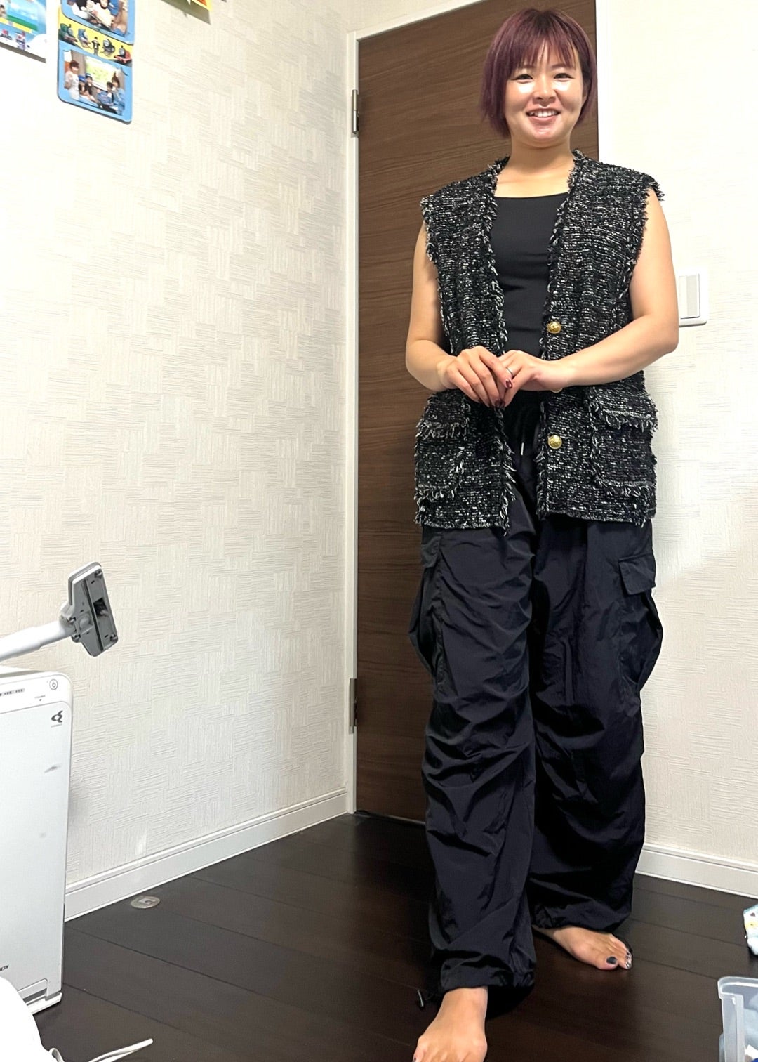 黒い表情のあるベストを黒いボリュームパンツに重ねた秋コーデ