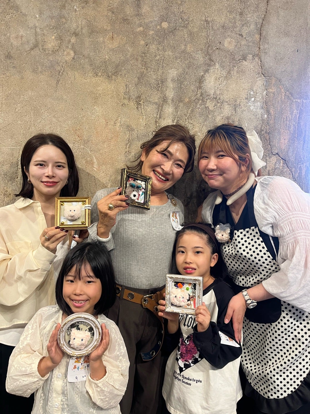 手作りした動物作品を手に笑顔を見せる女性と子どもたち