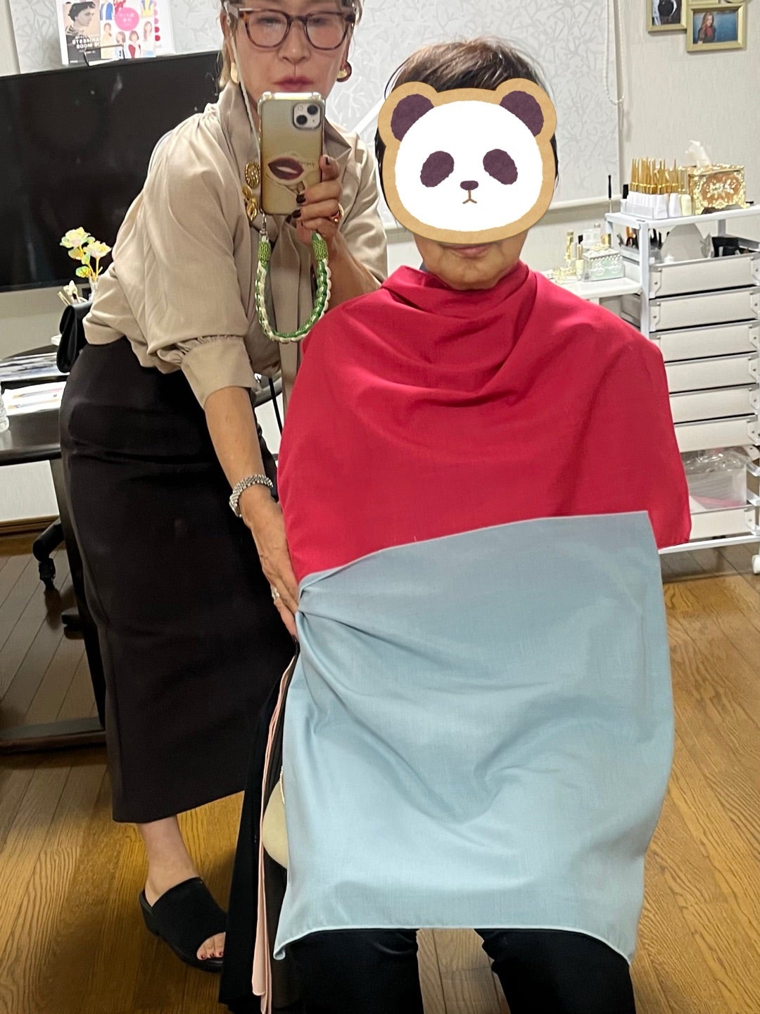 赤とブルーのカラードレープを当ててパーソナルカラーを確認するお客様
