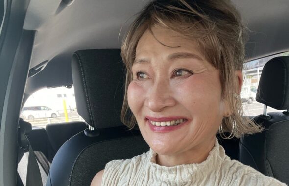 笑顔で白いトップスを着こなす女性
