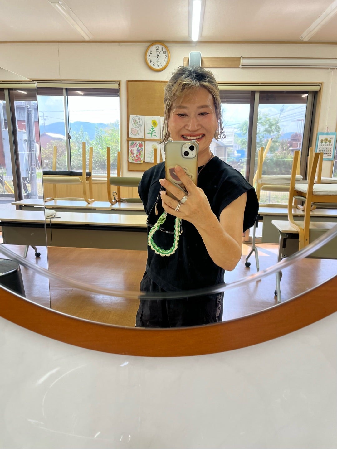 鏡の前で今日の着こなしを笑顔で確認する女性