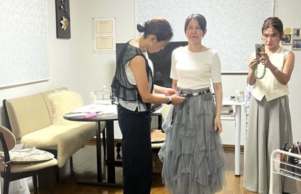 手持ちのベルトを使い着こなしを整える女性たち