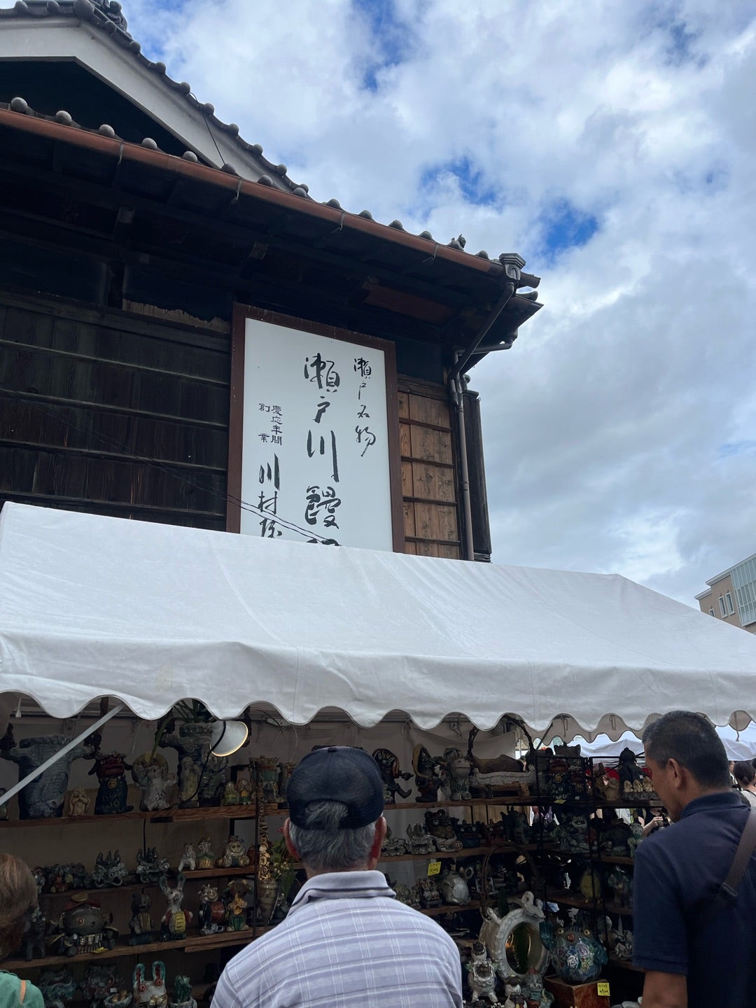 青空の下に並ぶ瀬戸の器や招き猫の店先