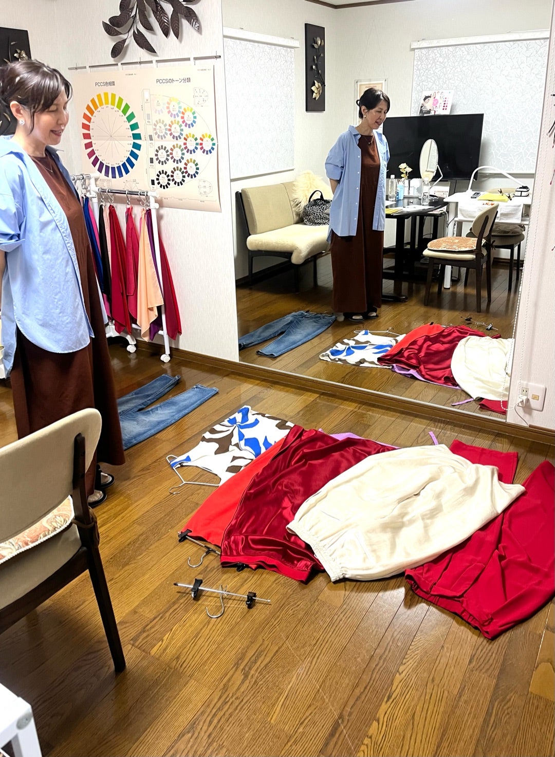 部屋に並べた服を見ながら毎日のコーデを考える様子