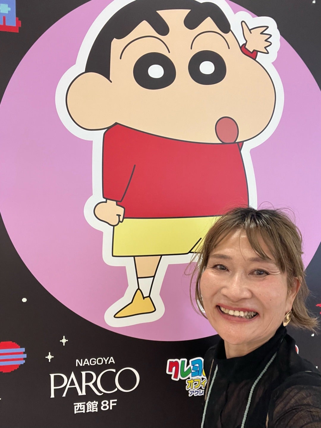 クレヨンしんちゃんのパネルの前で笑う三村由香