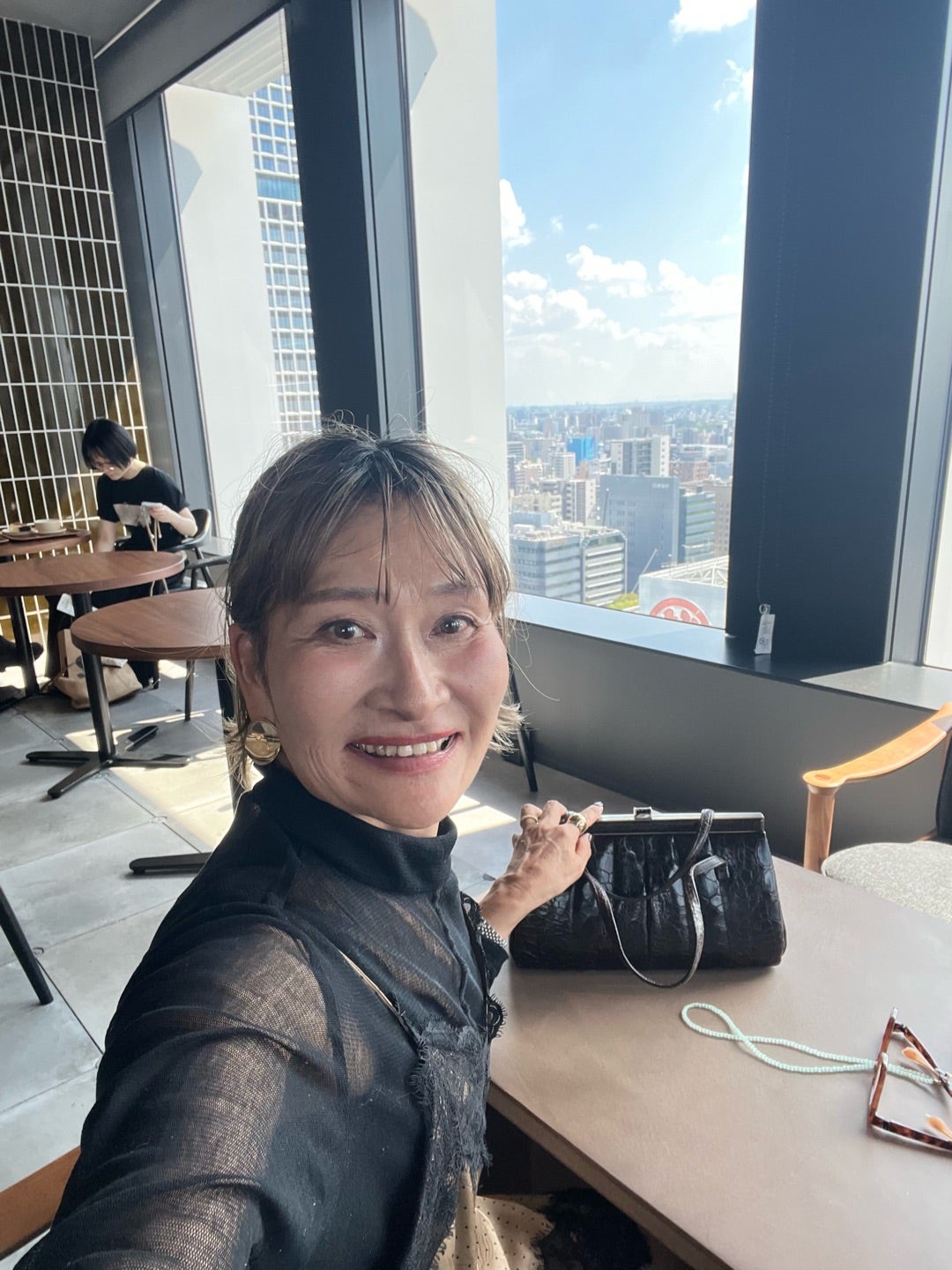 黒のシアートップスを着て笑顔を見せる三村由香