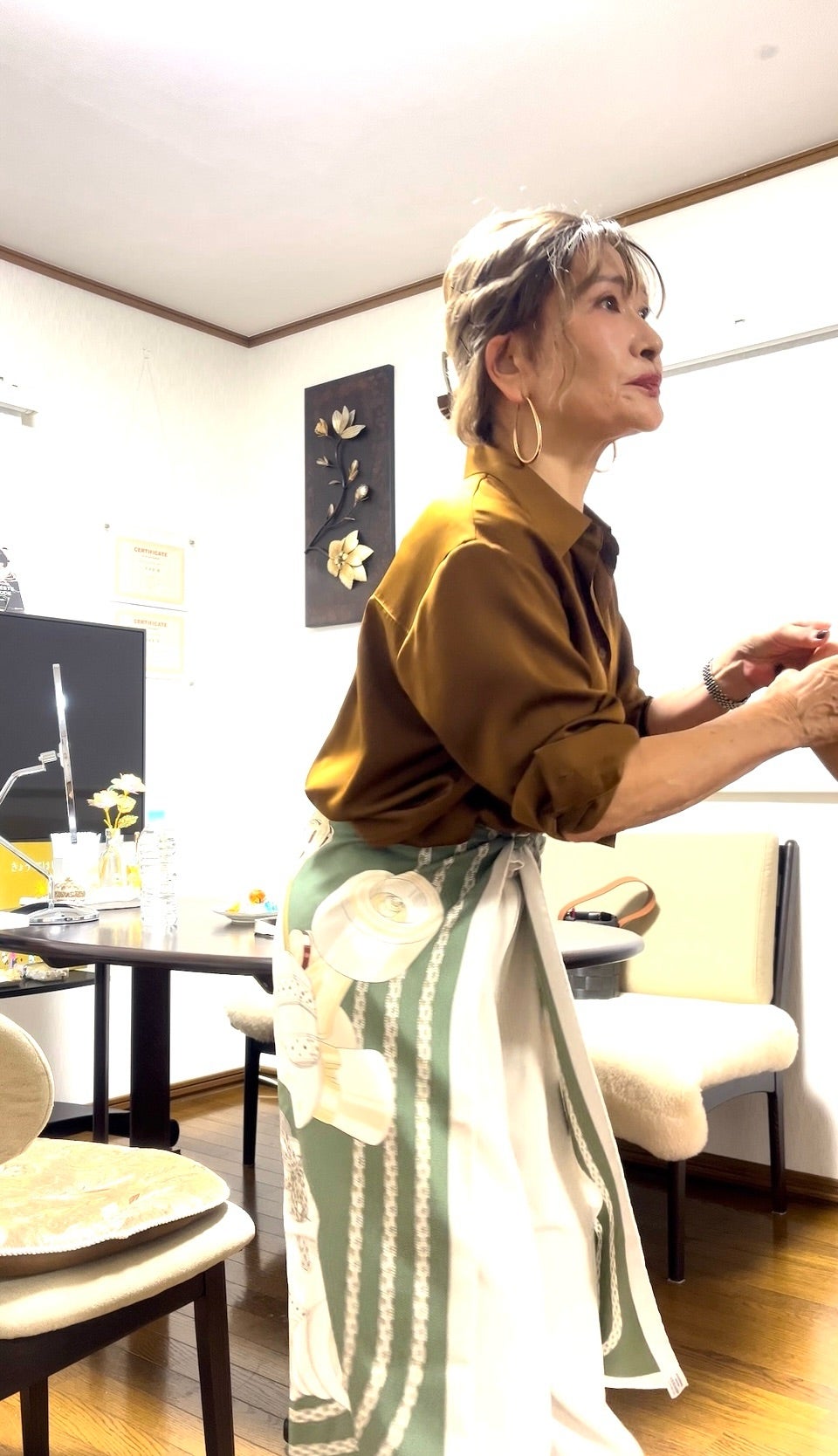 グリーンのスカーフを腰に巻く三村由香
