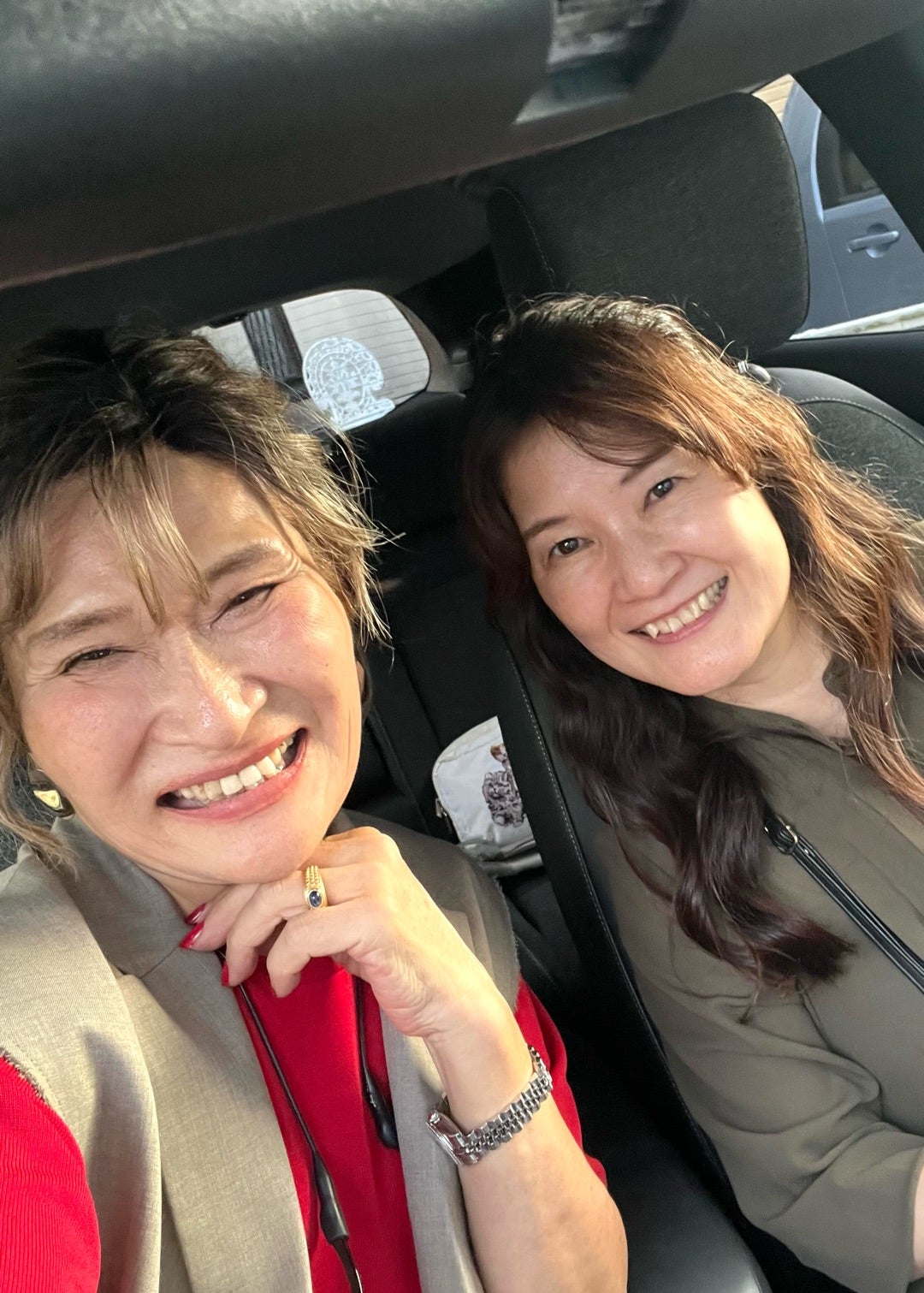 車内で笑顔を見せる三村由香とオリーブの装いの参加者