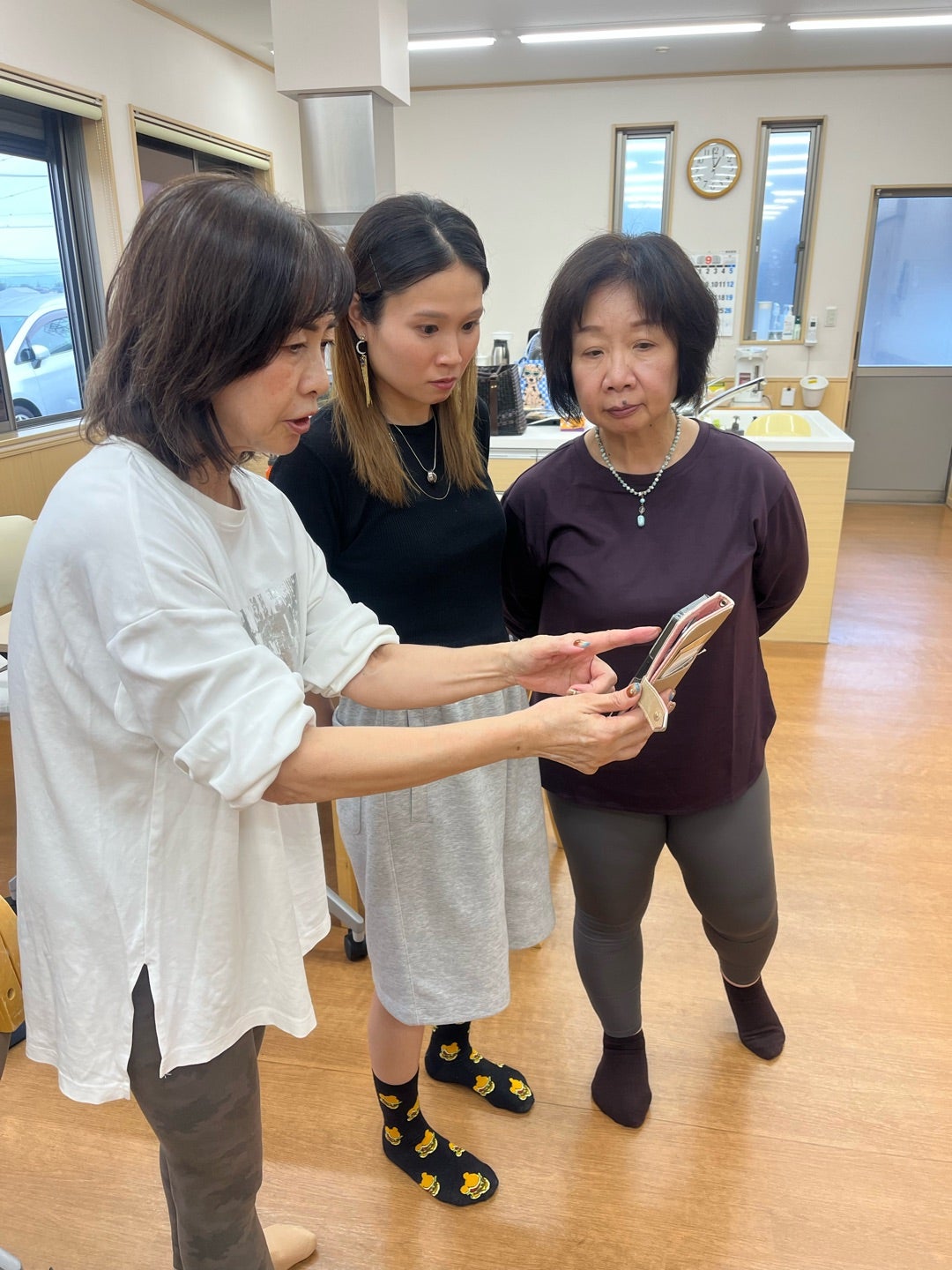 スマートフォンの画面を囲んで確認する参加者
