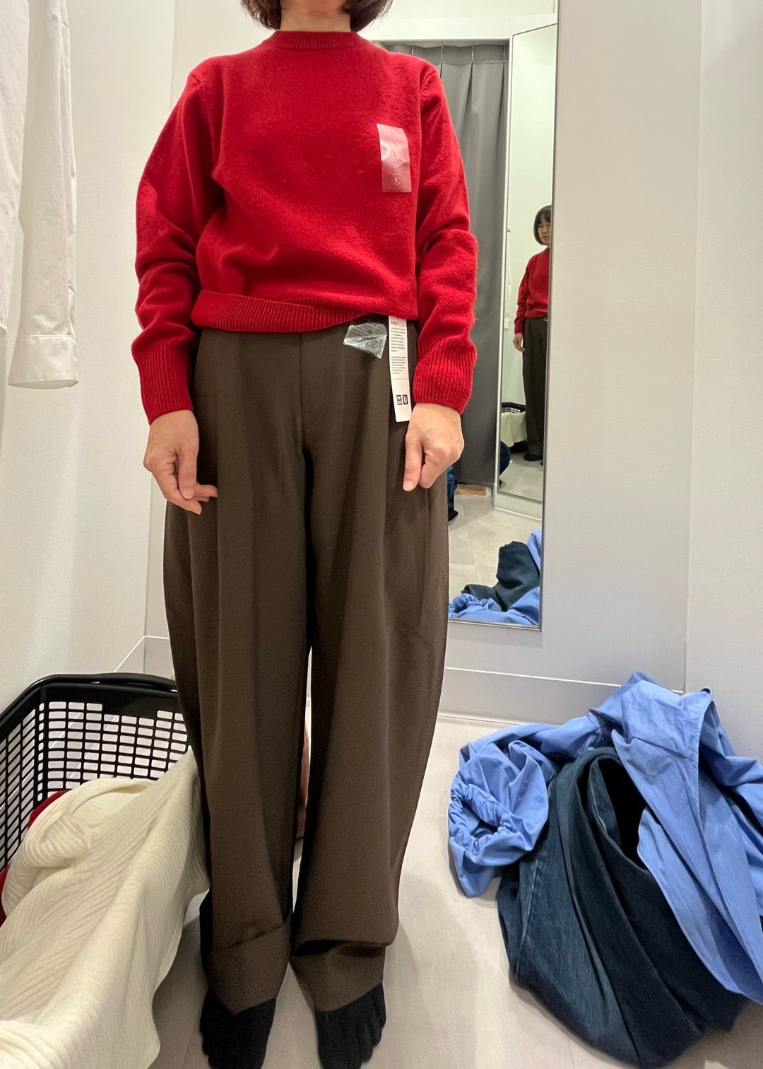 赤いニットとブラウンのバレルレッグパンツの試着姿