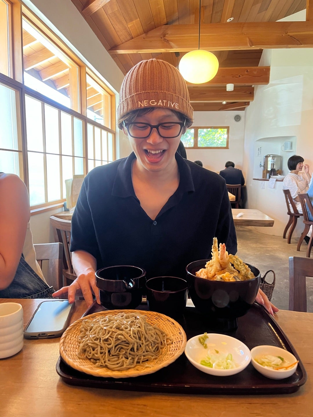 蕎麦と天ぷらを前に笑顔を見せる参加者
