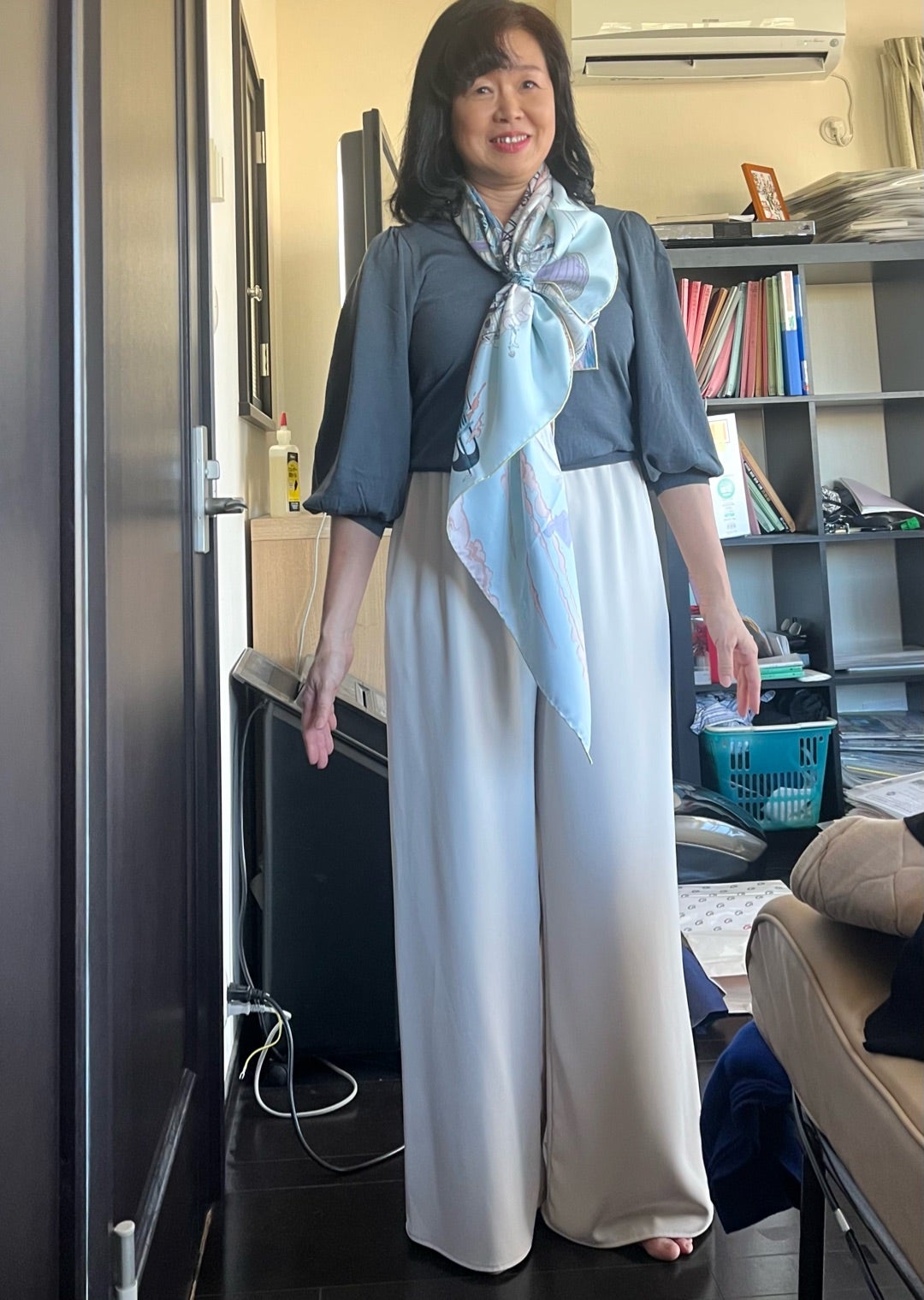 ブルー系のスカーフを首元に巻いた着こなし