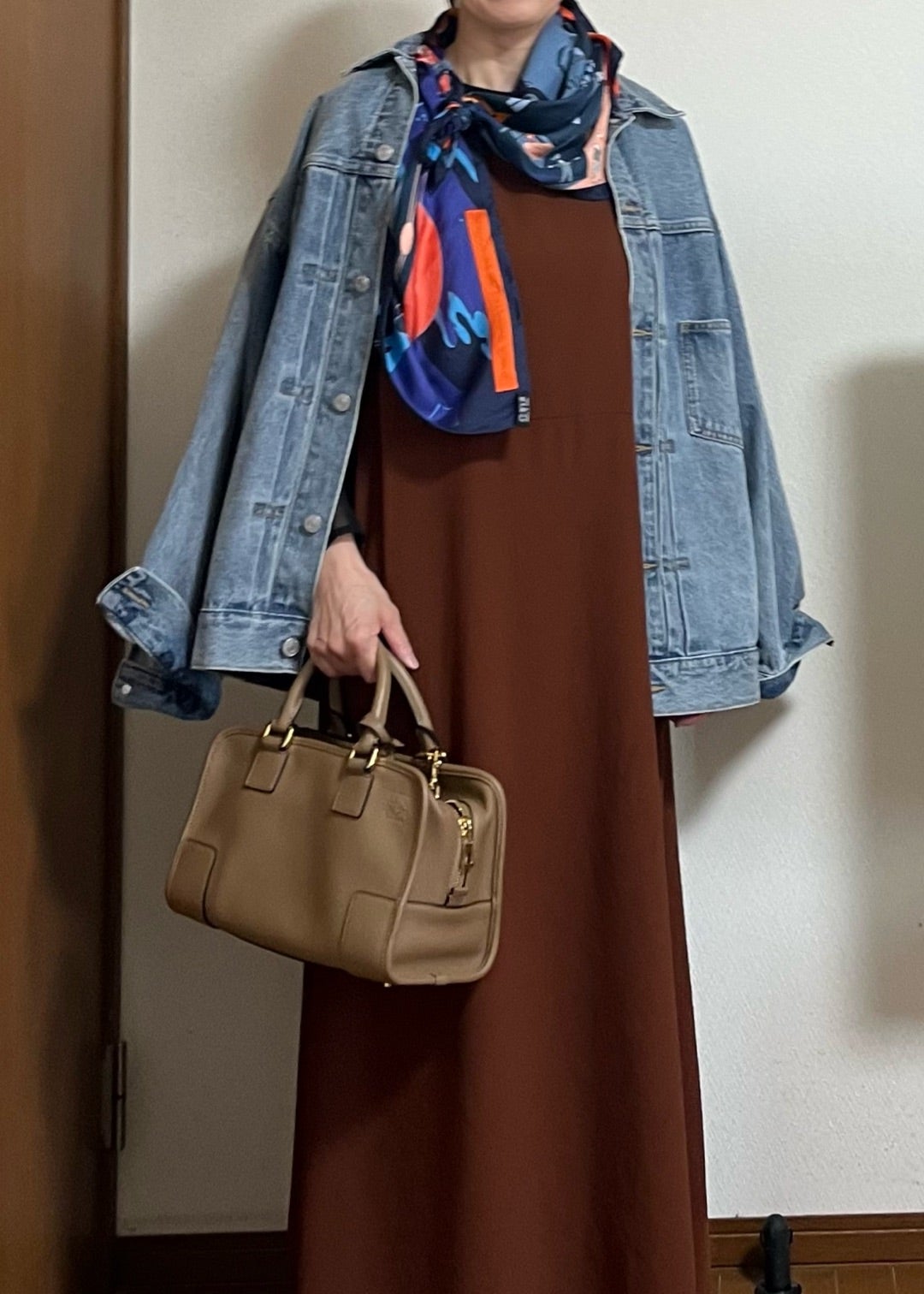 ブラウンの服にデニムの羽織りと柄のスカーフ、バッグを合わせた着こなし