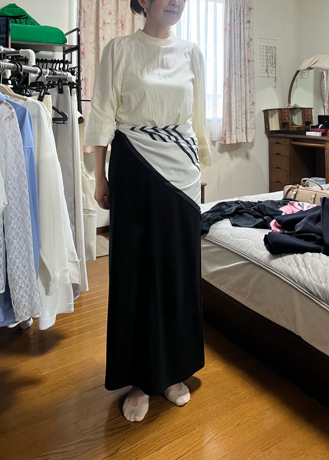 白いトップスの腰にスカーフを添えた着こなし