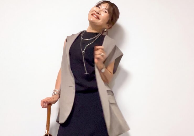 黒のノースリーブにグレージュのジレとネックレスを合わせた三村由香
